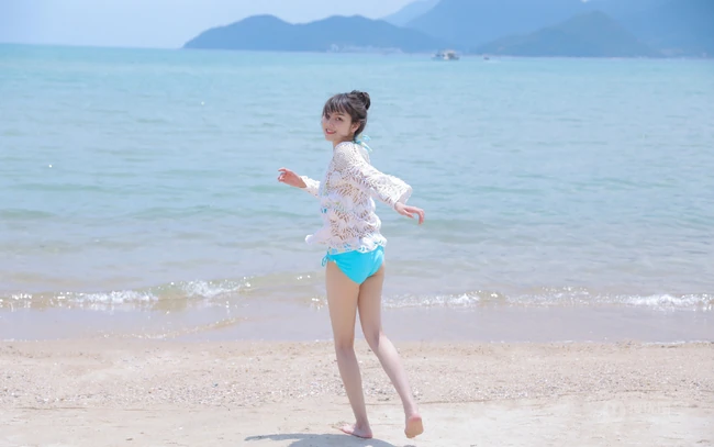 海边泳装女生，有点小微胖可爱丸子头泳装女生海边玩耍写真