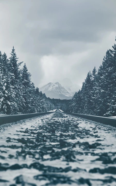 下雪林中的穿山铁路高清手机壁纸