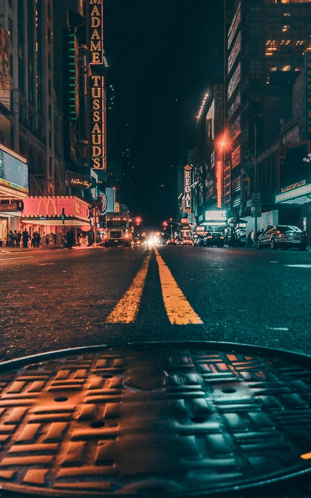 繁华城市夜景，夜间的城市街道井盖手机壁纸图片
