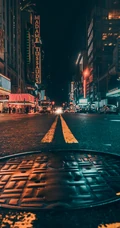 繁华城市夜景，夜间的城市街道井盖手机壁纸图片