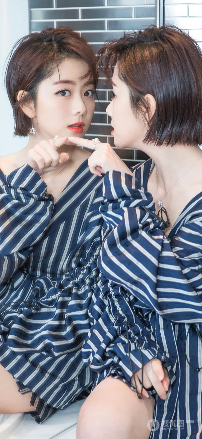 身穿黑蓝大衬衫的美女明星谭松韵对镜卖萌的手机桌面背景