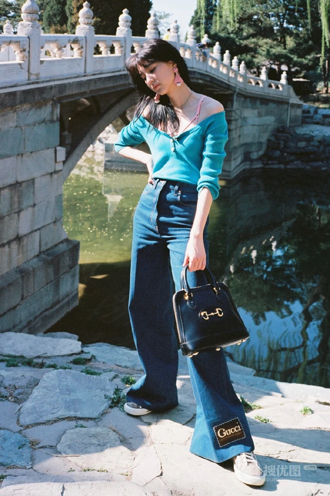 王悦伊公园湖边复古意境美照，V领上衣搭牛仔裤色彩复古照旧