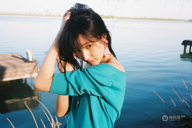 王悦伊公园湖边复古意境美照，V领上衣搭牛仔裤色彩复古照旧