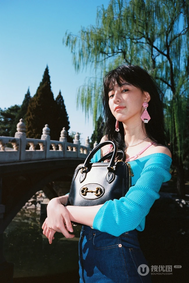 王悦伊公园湖边复古意境美照，V领上衣搭牛仔裤色彩复古照旧