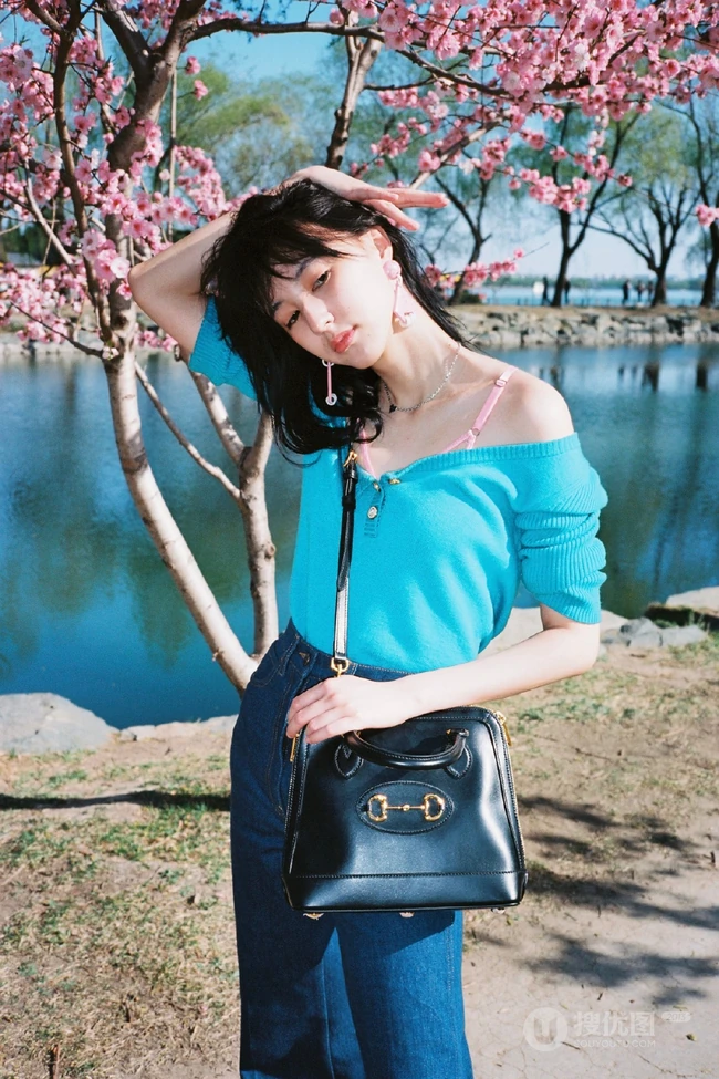 王悦伊公园湖边复古意境美照，V领上衣搭牛仔裤色彩复古照旧