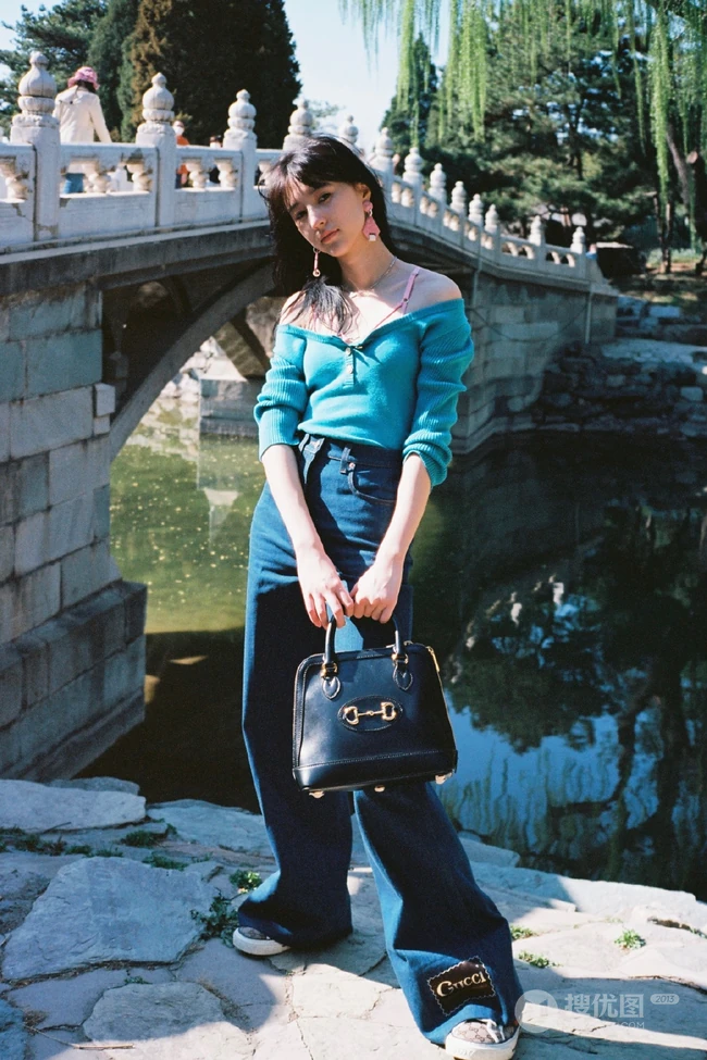 王悦伊公园湖边复古意境美照，V领上衣搭牛仔裤色彩复古照旧