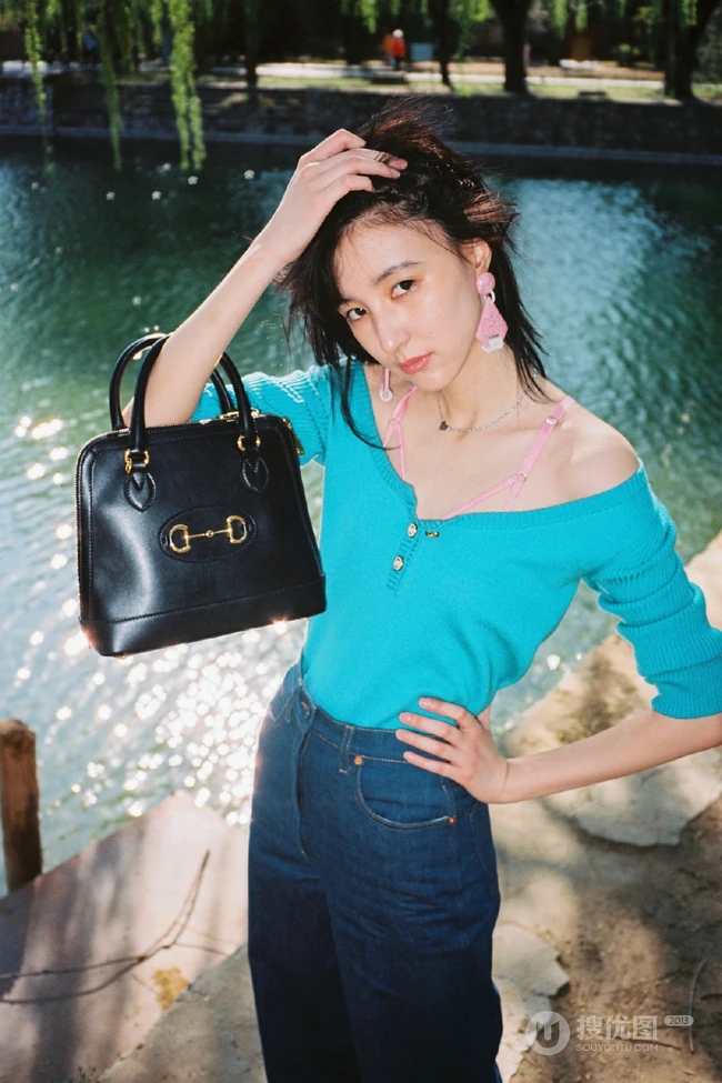 王悦伊公园湖边复古意境美照，V领上衣搭牛仔裤色彩复古照旧