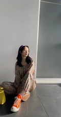 周雨彤穿着类似睡衣套装出现某写字楼，席地而坐，笑容满怀