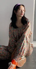 周雨彤穿着类似睡衣套装出现某写字楼，席地而坐，笑容满怀
