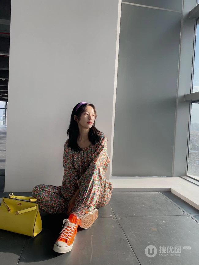 周雨彤穿着类似睡衣套装出现某写字楼，席地而坐，笑容满怀