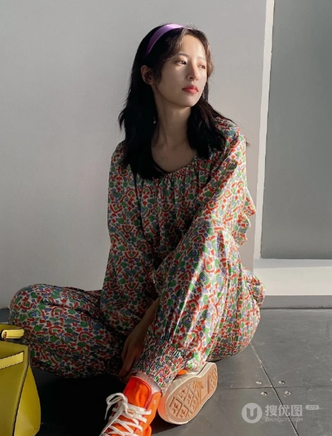 周雨彤穿着类似睡衣套装出现某写字楼，席地而坐，笑容满怀