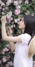 蔷薇花前戴草帽的白衣长裙妙龄好看少女甜美侧颜写真图片