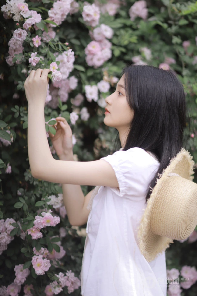 蔷薇花前戴草帽的白衣长裙妙龄好看少女甜美侧颜写真图片