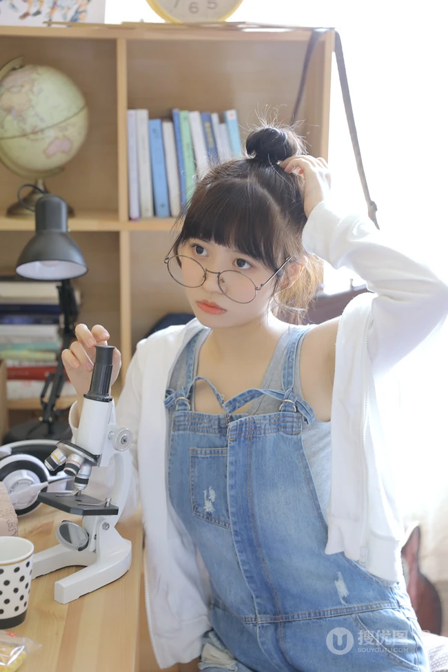 戴黑框眼镜的大眼萌圆脸少女室内玩显微镜可爱写真图片