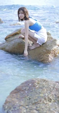 海边礁石上戏水的清凉蓝色背心短裤女生气质唯美写真图片