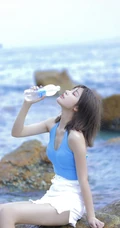 海边礁石上戏水的清凉蓝色背心短裤女生气质唯美写真图片