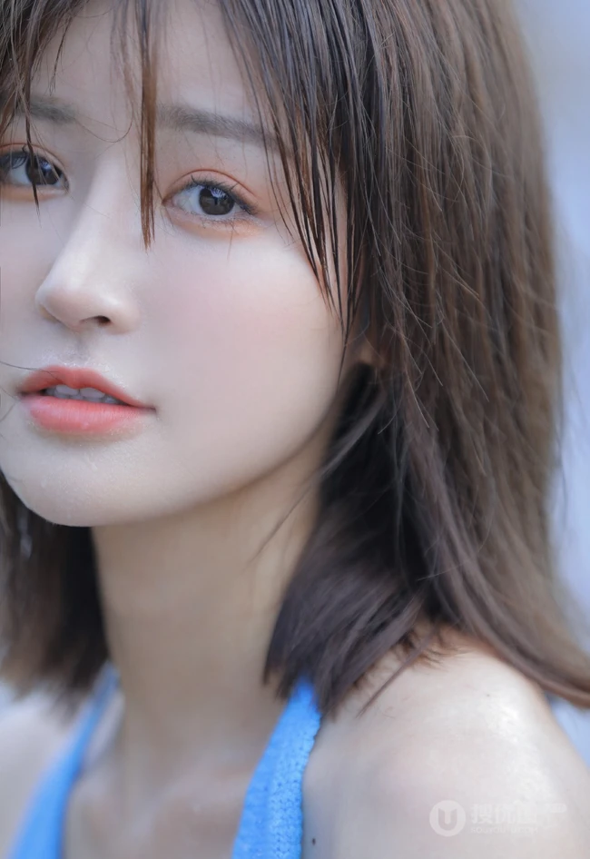 海边礁石上戏水的清凉蓝色背心短裤女生气质唯美写真图片