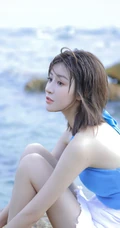 海边礁石上戏水的清凉蓝色背心短裤女生气质唯美写真图片