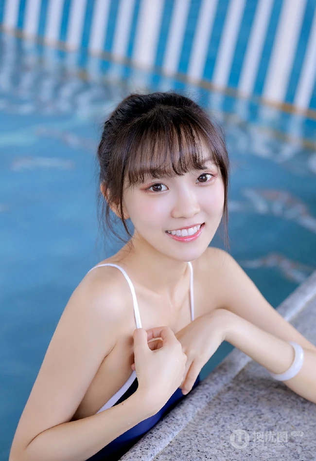 甜美白皙丸子头女生着气质蓝色肩带死库水泳池玩水清透写真图片