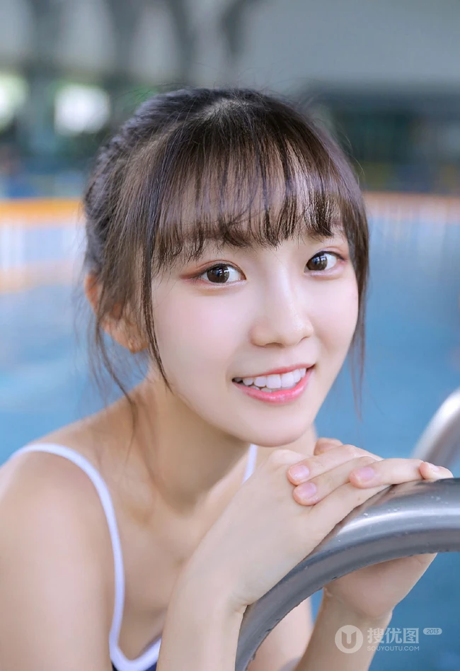 甜美白皙丸子头女生着气质蓝色肩带死库水泳池玩水清透写真图片