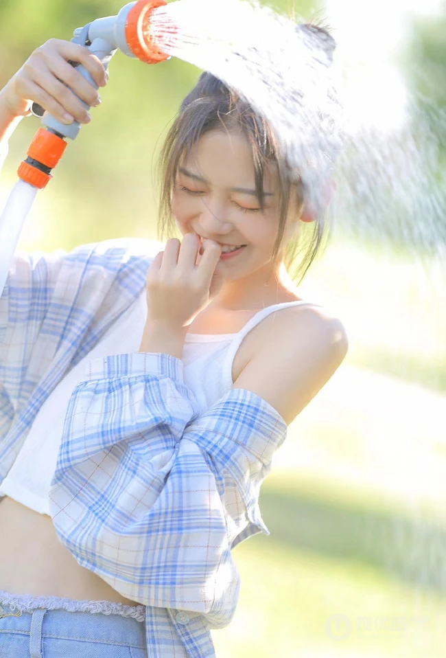 户外草坪里玩水龙头的可爱女生，背心短裤加格子衬衫全湿透，清凉无比