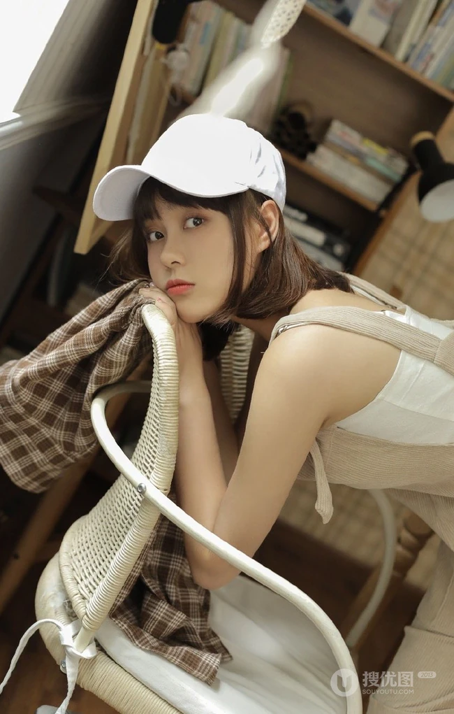 戴棒球帽的短发女生小姐姐穿着好看的背带裤居家悠闲写真图片