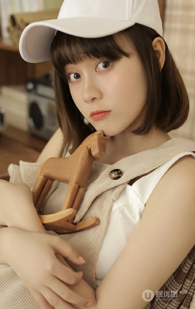 戴棒球帽的短发女生小姐姐穿着好看的背带裤居家悠闲写真图片