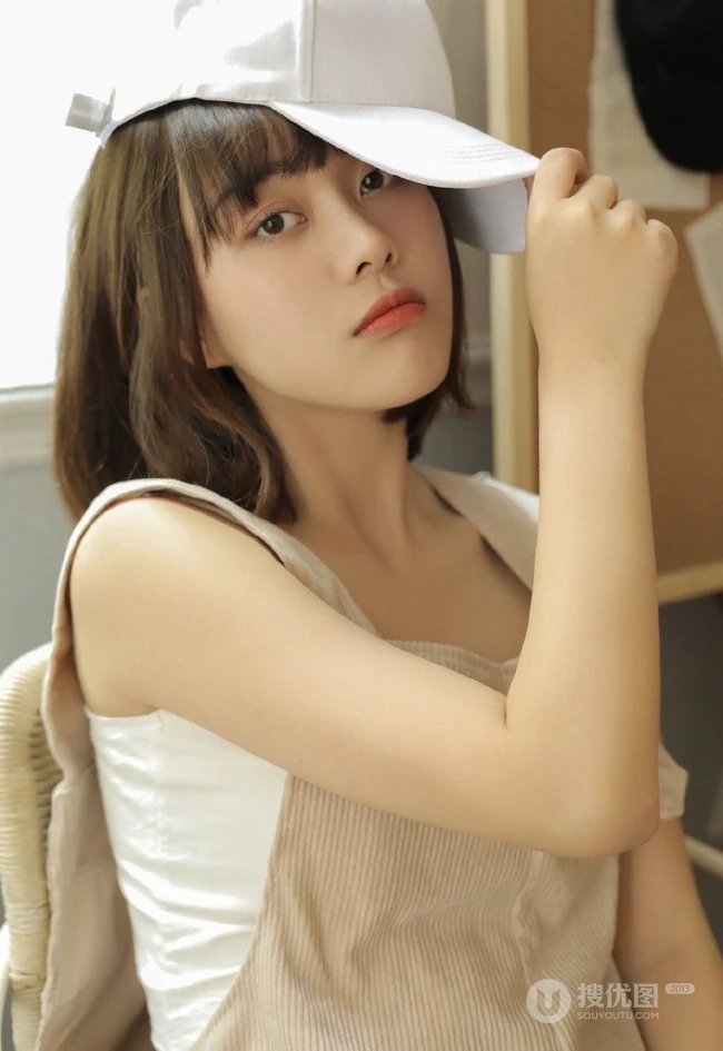 戴棒球帽的短发女生小姐姐穿着好看的背带裤居家悠闲写真图片