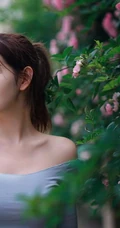 气质美丽女孩蔷薇花前驻足流连，着V领上衣搭牛仔裙艺术摄影图片
