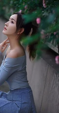 气质美丽女孩蔷薇花前驻足流连，着V领上衣搭牛仔裙艺术摄影图片