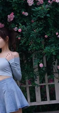 气质美丽女孩蔷薇花前驻足流连，着V领上衣搭牛仔裙艺术摄影图片