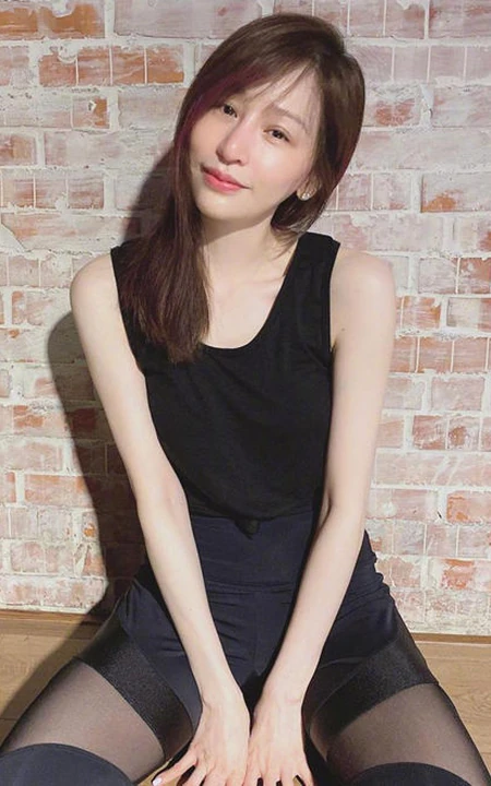 王心凌黑色背心搭配轻纱袜装拼接长裤蹲坐气质图片