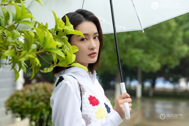 李沁手拿雨伞雨天出街，白衣短裙气质清新