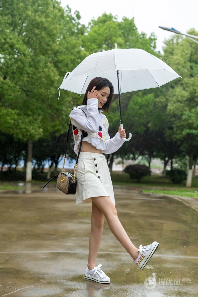李沁手拿雨伞雨天出街，白衣短裙气质清新
