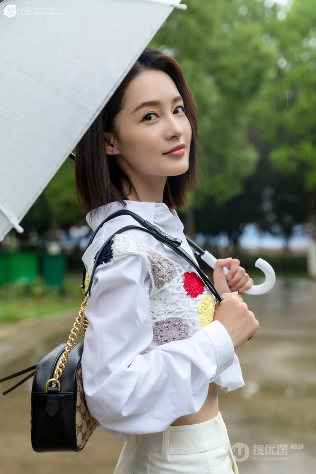 李沁手拿雨伞雨天出街，白衣短裙气质清新