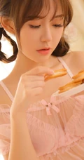 浅粉羞涩的00后漂亮女生很甜很撩粉色蕾丝裙室内吃零食写真图片