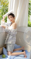 夏日穿着清凉肩带背心短裤的女孩慵懒吹风扇悠闲写真图片