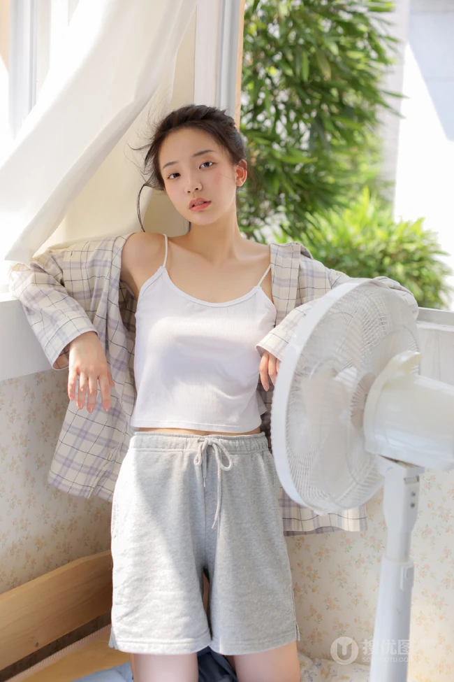 夏日穿着清凉肩带背心短裤的女孩慵懒吹风扇悠闲写真图片