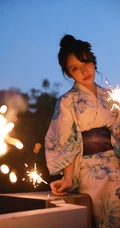 夜幕快降临时手拿燃烧烟花棒的和服装漂亮清新女生唯美写真