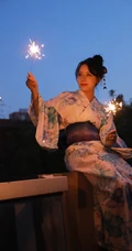 夜幕快降临时手拿燃烧烟花棒的和服装漂亮清新女生唯美写真