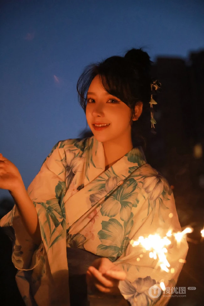 夜幕快降临时手拿燃烧烟花棒的和服装漂亮清新女生唯美写真