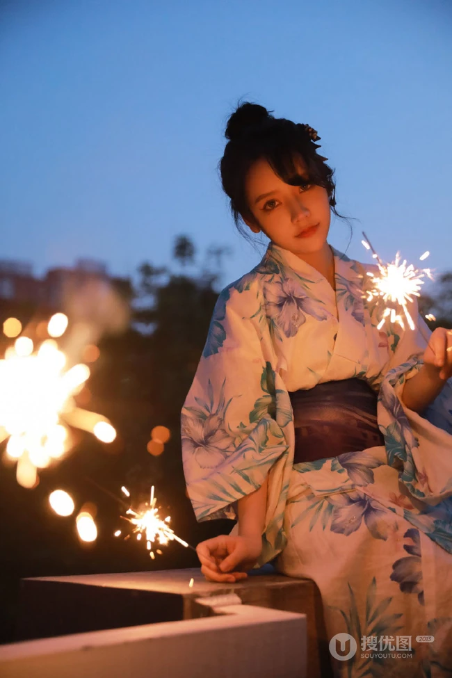 夜幕快降临时手拿燃烧烟花棒的和服装漂亮清新女生唯美写真