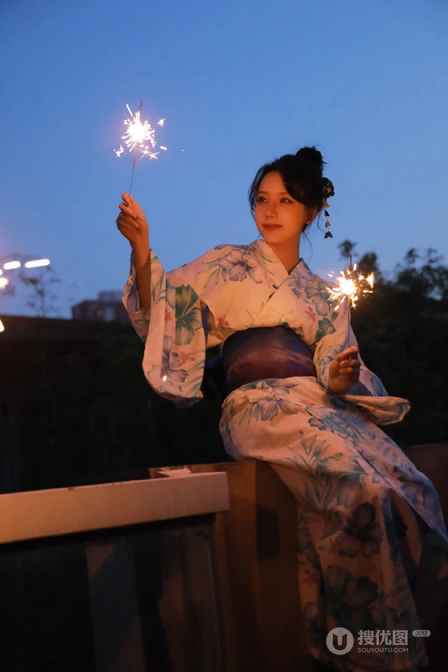 夜幕快降临时手拿燃烧烟花棒的和服装漂亮清新女生唯美写真