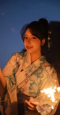 夜幕快降临时手拿燃烧烟花棒的和服装漂亮清新女生唯美写真