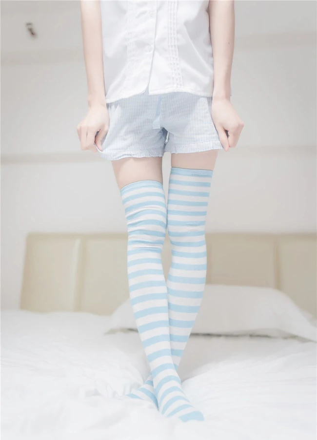 穿条纹长筒袜的娇小玲珑短裤女生，简单快乐室内清新写真图片