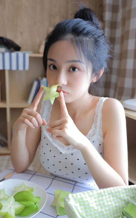 手拿杨桃的清纯丸子头少女清新室内写真