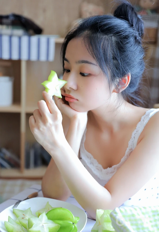 手拿杨桃的清纯丸子头少女清新室内写真