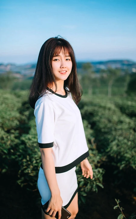 茶山上背着相机的美丽白衣短裙女生唯美户外摄影美图
