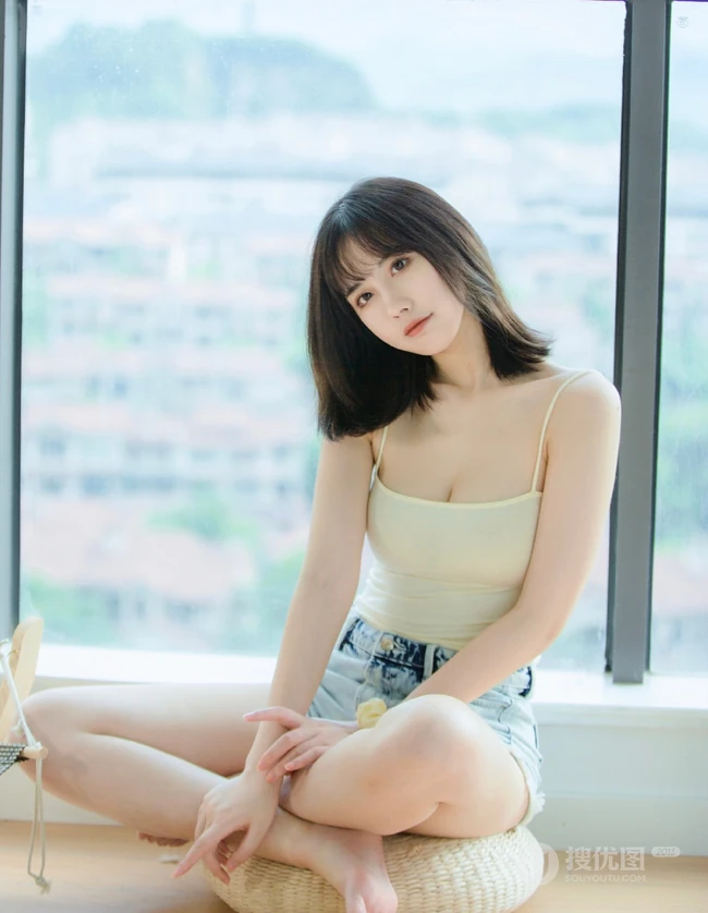 气质匀称温柔型圆脸女生，肩带衣搭牛仔热裤居家悠闲写真吸睛美照