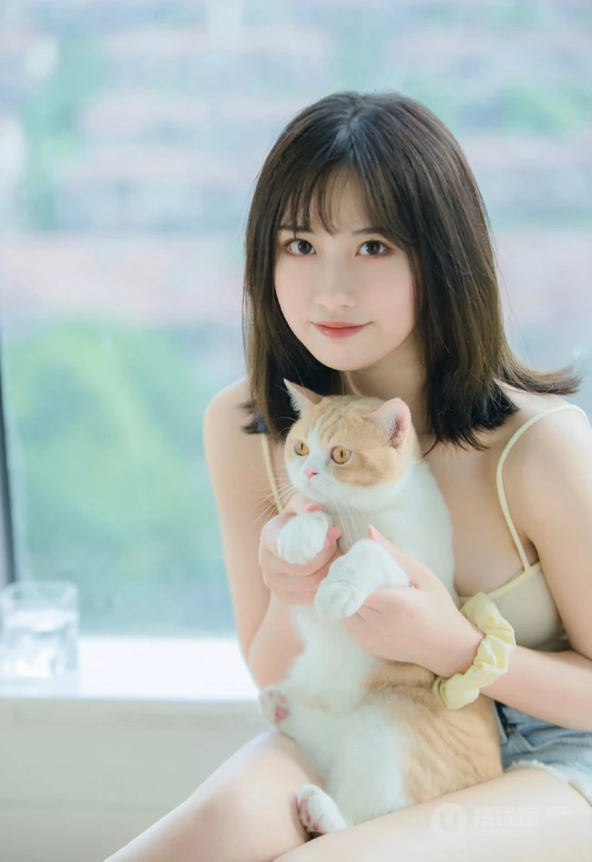 气质匀称温柔型圆脸女生，肩带衣搭牛仔热裤居家悠闲写真吸睛美照